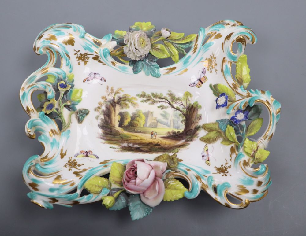 A 19th century Coalbrookdale porcelain two handled basket, painted with figures in a landscape and encrusted with flowers